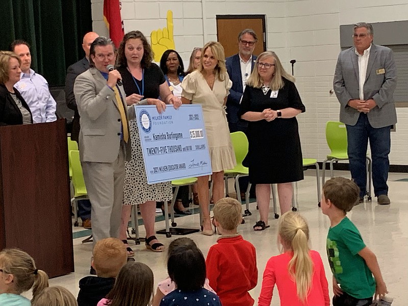 NWA Democrat-Gazette/JANELLE JESSEN Kamisha Burlingame, a fourth-grade teacher at Bentonville's Thomas Jefferson Elementary School, holds an oversized check for $25,000 that she received for being named a Milken Educator Award winner during a surprise announcement Wednesday.