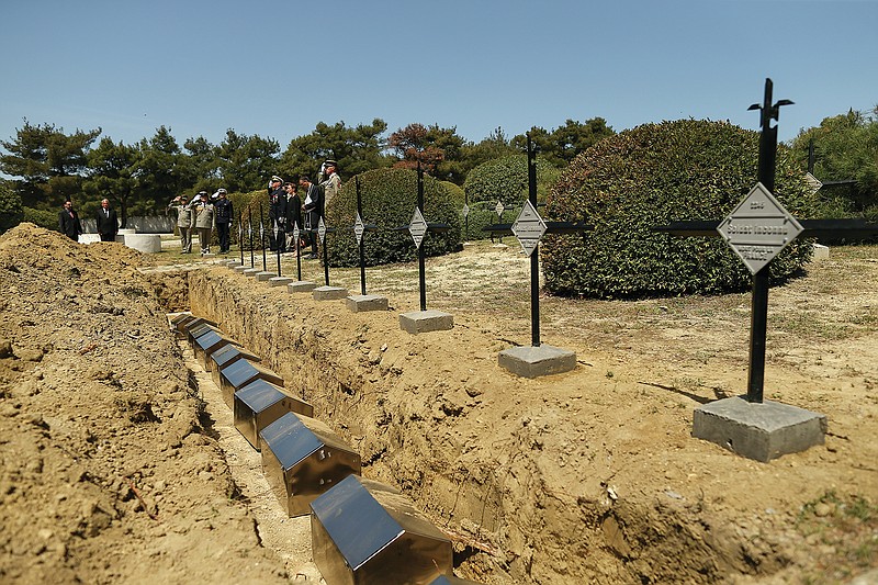 French army officers salute after they have placed the remains of 17 missing French soldiers who fought in the World War I Battle of Gallipoli, in Canakkale, Turkey, Sunday, April 24, 2022. The remains were on Sunday handed over to French military officials and put to rest alongside other fallen comrades, more than a hundred years after their deaths. The remains were found during restoration work on a castle and surrounding areas on Turkey's northwestern Canakkale peninsula, where Allied forces fought against Ottoman Turks in the ill-fated Gallipoli campaign that started with landings on the peninsula on April 25, 1915. (AP Photo/Emrah Gurel)