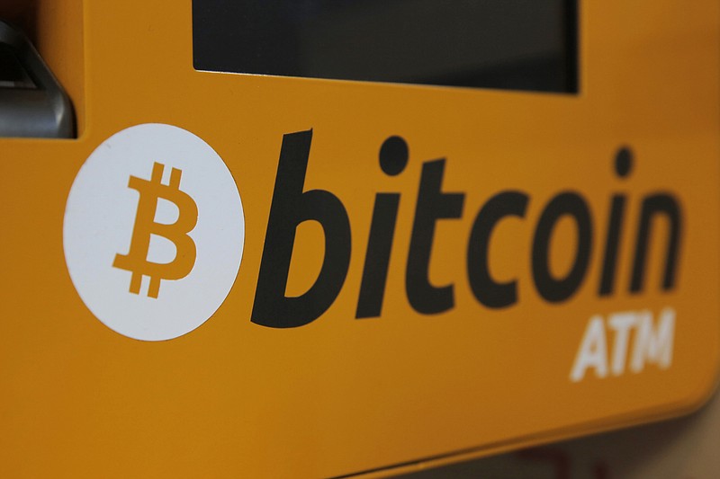 FILE - A Bitcoin logo is displayed on an ATM in Hong Kong, Thursday, Dec. 21, 2017.  More workers may soon be able to stake some of their 401(k) retirement savings to bitcoin, as cryptocurrencies crack even deeper into the mainstream.  Retirement giant Fidelity said Tuesday, April 26, 2022, that it’s launched a way for workers to put some of their 401(k) savings and contributions directly in bitcoin, potentially up to 20%, all from the account’s main menu of investment options. Fidelity said it’s the first in the industry to allow such investments without having to go through a separate brokerage window, and it's already signed up one employer that will add the offering to its plan later this year.  (AP Photo/Kin Cheung, File)