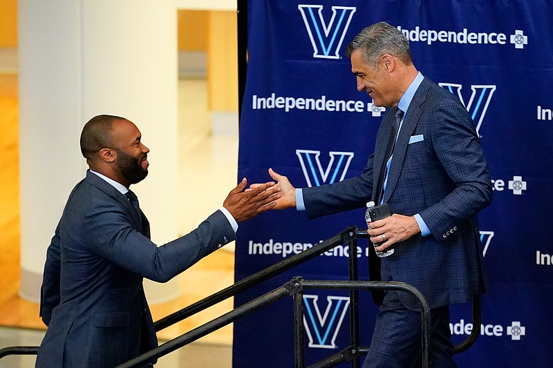 Villanova NCAA college basketball coach Kyle Neptune, left, greets retiring coach Jay Wright during a news conference in Villanova, Pa., Friday, April 22, 2022. (AP Photo/Matt Rourke)