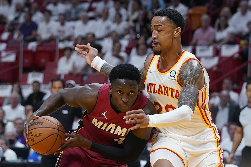 Miami Heat guard Victor Oladipo, right, looks for an opening past