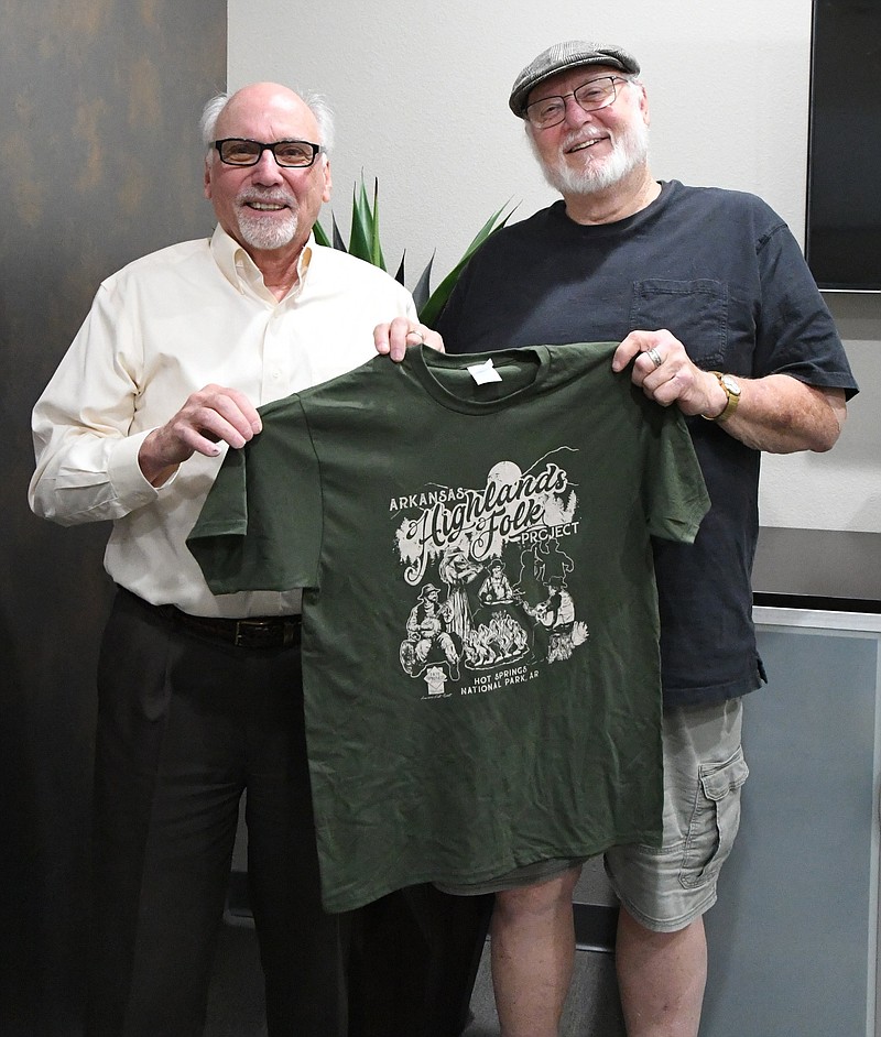 Charlie Moore, left, and Charlie Mink, concert organizers, hold up an event shirt for the upcoming festival. - Photo by Tanner Newton of The Sentinel-Record