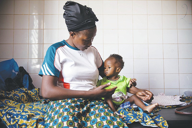 Martine Roamba and her 10-month-old daughter Leïla sit in the pediatric department of Boulmiougou hospital in Ouagadougou, Burkina Faso, Friday April 15, 2022. The malnourished baby has been struggling to feed since birth as her mother doesn't produce sufficient breastmilk _ she has been mostly starving since fleeing her village in northern Burkina Faso last year when jihadis started killing people. (AP Photo/Sophie Garcia)