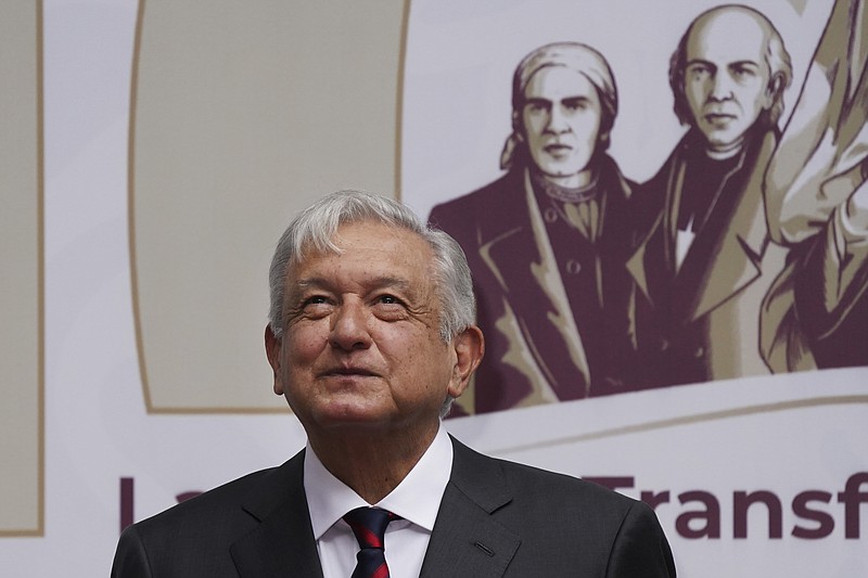 FILE - Mexican President Andres Manuel Obrador smiles as people applaud after the playing of the national anthem at the end of an event where he delivered a speech on economic figures, in Mexico City, Tuesday, April 12, 2022.  On the third week of April, Lopez Obrador strong-armed a U.S. gravel company into agreeing to operate a tourist resort and cruise ship dock at rock quarries it owns on the Caribbean coast.  (AP Photo/Marco Ugarte, File)