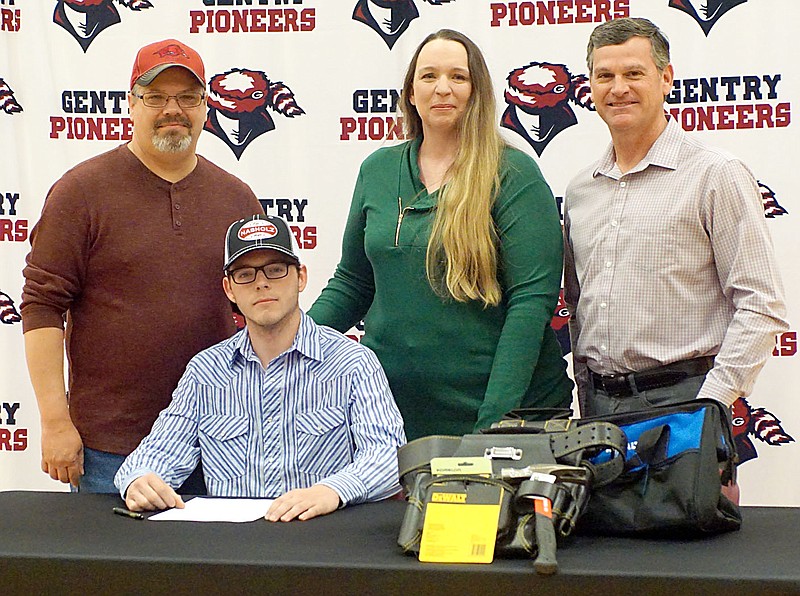 Westside Eagle Observer/RANDY MOLL
Gentry senior Noah Folger â€” with parents Charles (left) and Andrea Folger and Nabholz president Michael Parker behind himÂ â€”Â signed a letter accepting an apprenticeship with Nabholz Contruction. Folger will go to work for Nabholz Construction and receive specialized training in parts of the construction trade. Folger's signing was a first at Gentry High School, with a student signing to join a company and enter a skilled trade.