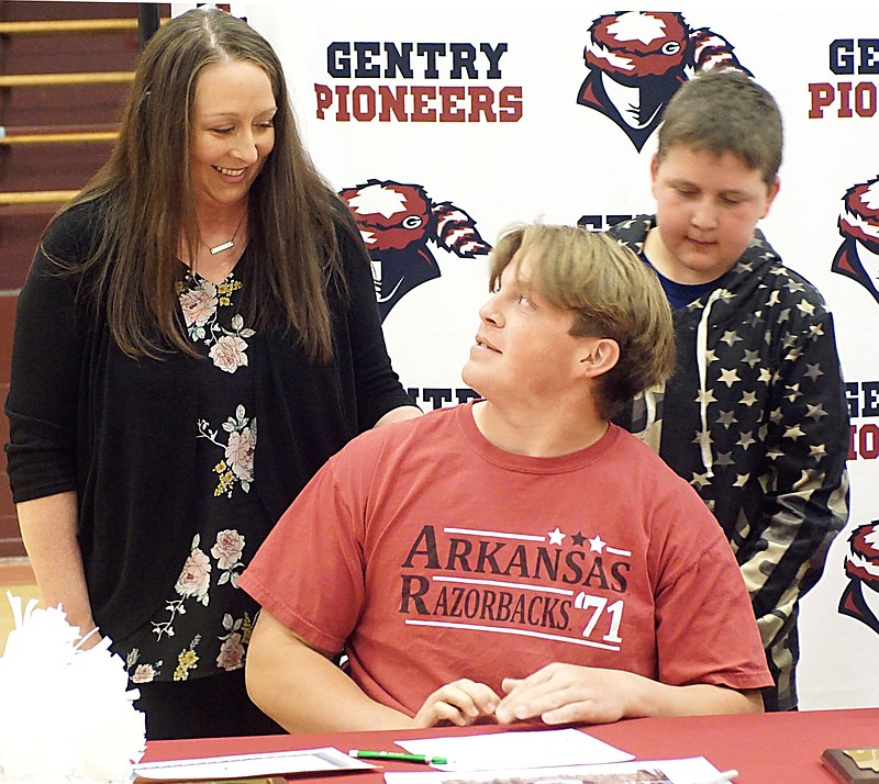 Westside Eagle Observer/RANDY MOLL
Gentry High School senior Lucas Guinn looks up at his mother, Stephanie Guinn, on April 28 while brother Jax looks on after Lucas signed to be a part of the University of Arkansas Razorback cheer squad in the fall.