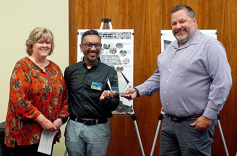 Westside Eagle Observer/RANDY MOLL
Doctors Ashish Mathur and John Caswell received the business of the year award from Gentry Chamber of Commerce director Janie Parks during a special Chamber-sponsored community event held in the McKee Community Room of the Gentry Public Library on Thursday evening. Medical clinic nurses and staff members were also on hand for the award.