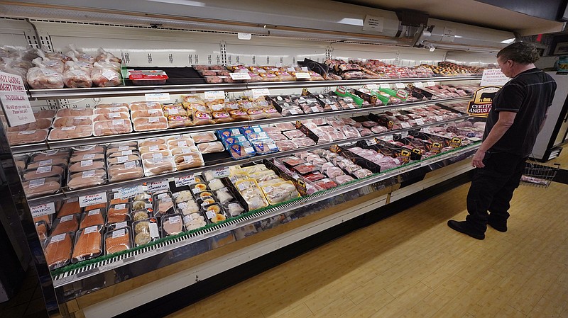 A man browses in the meat department at Lambert's Rainbow Market, on June 15, 2021 in Westwood, Mass. February food prices were 7.9% higher compared with a year ago and are expected to increase 4.5% to 5.5% in 2022. As a result, it can feel harder than ever to keep grocery spending under control. But budgeting and cooking experts say there are strategies you can apply to save money and make a difference in your household budget. (AP Photo/Charles Krupa)