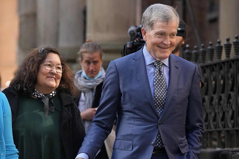 Steve Johnson, right, and his wife Rosemarie arrive at the Supreme Court in Sydney, Monday, May 2, 2022, for a sentencing hearing in the murder of Scott Johnson, Steve's brother. Scott White appeared in the New South Wales state Supreme Court for a sentencing hearing after he pleaded guilty in January to the murder of the Los Angeles-born Canberra resident Scott Johnson, whose death at the base of a North Head cliff was initially dismissed by police as suicide. (AP Photo/Rick Rycroft)