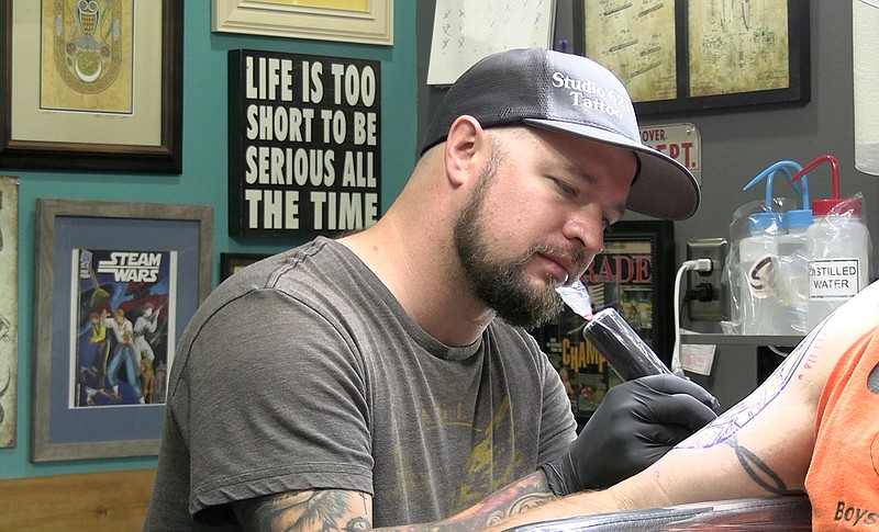 Tattoo artist and owner of Studio 621 Tattoo, Matt Pumphrey works on a client's tattoo on Monday. – Photo by Andrew Mobley of The Sentinel-Record