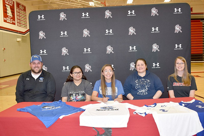 RACHEL DICKERSON/MCDONALD COUNTY PRESS Jazmine Belland, center, is pictured signing to play soccer for Crowder College in Neosho. Pictured, left to right, Crowder College Soccer Coach Jason Bond, Ana Martina Reyna Trevino, Jazmine Belland, Erika Reyna, McDonald County High School Assistant Soccer Coach Emilee Sumler.