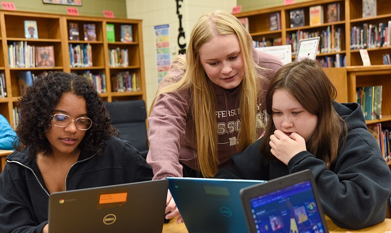 Lewis and Clark Middle School teacher Katie Verry, standing, shows students Taylor Brown, left, and Reice Flowers what to look for in the online project they were working on Wednesday, May 4, 2022. (Julie Smith/News Tribune photo)