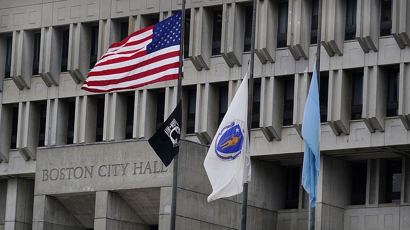 The American flag, the Commonwealth of Massachusetts flag, and the City of Boston flag, from left, fly outside Boston City Hall, Monday, May 2, 2022, in Boston. A unanimous Supreme Court has ruled that Boston violated the free speech rights of a conservative activist when it refused his request to fly a Christian flag on a flagpole outside City Hall. Justice Stephen Breyer wrote for the court Monday that the city discriminated against the activist because of his "religious viewpoint," even though it had routinely approved applications for the use of one of the three flagpoles outside City Hall that fly the U.S., Massachusetts and Boston flags. (AP Photo/Charles Krupa)