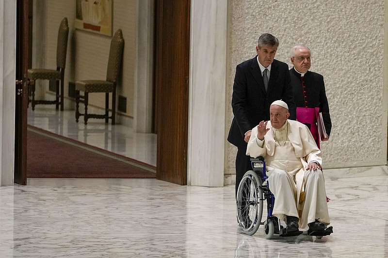 Pope Francis arrives in a wheelchair Thursday at the Paul VI Hall at the Vatican with aide Monsignor Leonardo Sapienza (right).
(AP/Alessandra Tarantino)