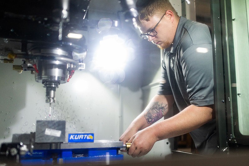 Alex Murdock, assistant in the Electrical, Industrial Maintenance and Instrumentation programs at Texarkana College, performs a demonstration using the HAAS DM-1 CNC machine. The machine's purpose is to remove material precisely, up to .0001 inch. The program is an example of the type of workforce training the Texas Higher Education Coordinating Board is emphasizing in its latest strategic plan. (Gazette staff photo)