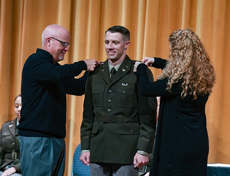 CJ Closser stands on stage in Mitchell Auditorium with his parents Tim and Kim Closser as they pin the bar of second lieutenant on him during a ceremony Friday, May 6, 2022. Lincoln University Army ROTC hosted the commissioning ceremony during which eight cadets were sworn in as second lieutenants in the U.S. Army. (Julie Smith/News Tribune photo)