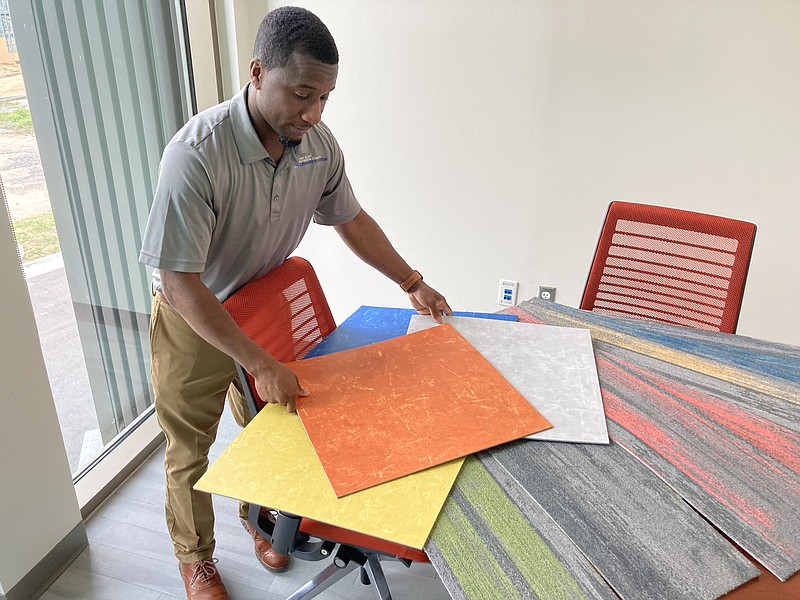 New, quieter flooring is in store for the Pine Bluff Public Library. Here, Library Director Ricky Williams shows off some carpet and flooring samples. (Pine Bluff Commercial/Byron Tate)