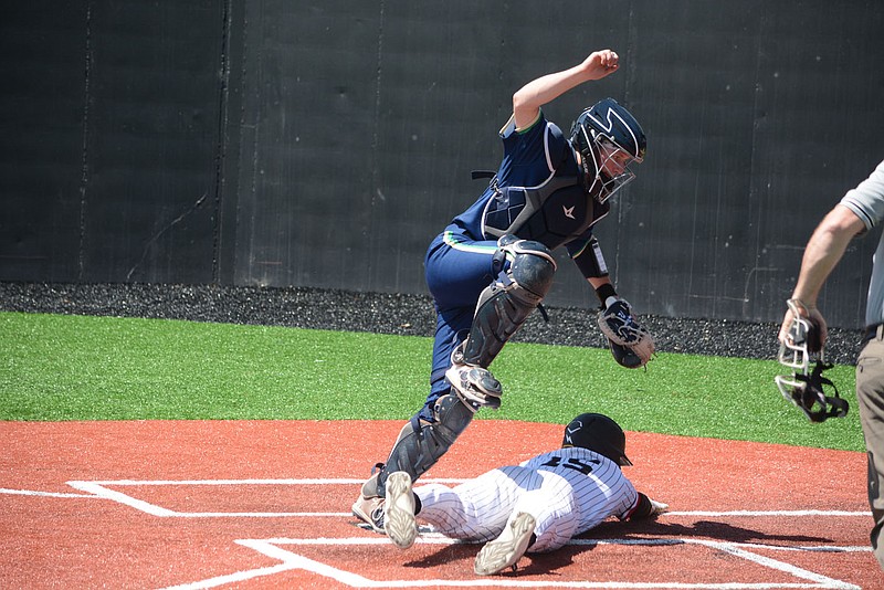 BENNETT HORNE/MCDONALD COUNTY PRESS McDonald County sophomore Destyn Dowd slides across the plate while Catholic catcher Logan Ripper leaps over him to go get the ball during the Big 8 Championship game Saturday, May 7. The Mustangs won the game, 7-1.