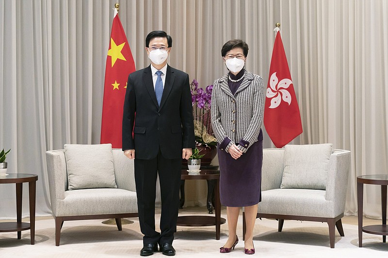 Hong Kong Chief Executive-elect John Lee, left, and Chief Executive Carrie Lam pose for a photo during a meeting at the Central Government Complex ahead of a news conference in Hong Kong, Monday, May 9, 2022. (Anthony Kwan/Pool Photo via AP)