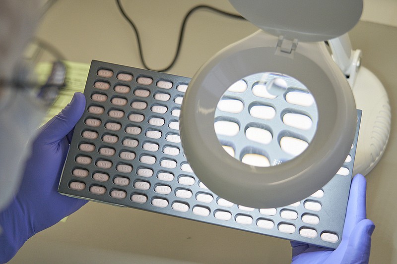 FILE - In this photo provided by Pfizer, a lab technician visually inspects COVID-19 Paxlovid tablet samples in Freiburg, Germany in December 2021. As more doctors prescribe Pfizer's powerful COVID-19 pill, new questions are emerging about its performance, including why a small number of patients appear to relapse after taking the drug. (Pfizer via AP, File)