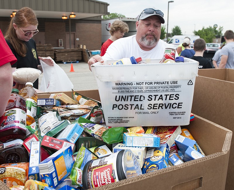 Carlos Robinett, of the Samaritan Center, helps unload food collected during the USPS Letter Carriers Drive in 2018. (News Tribune file)