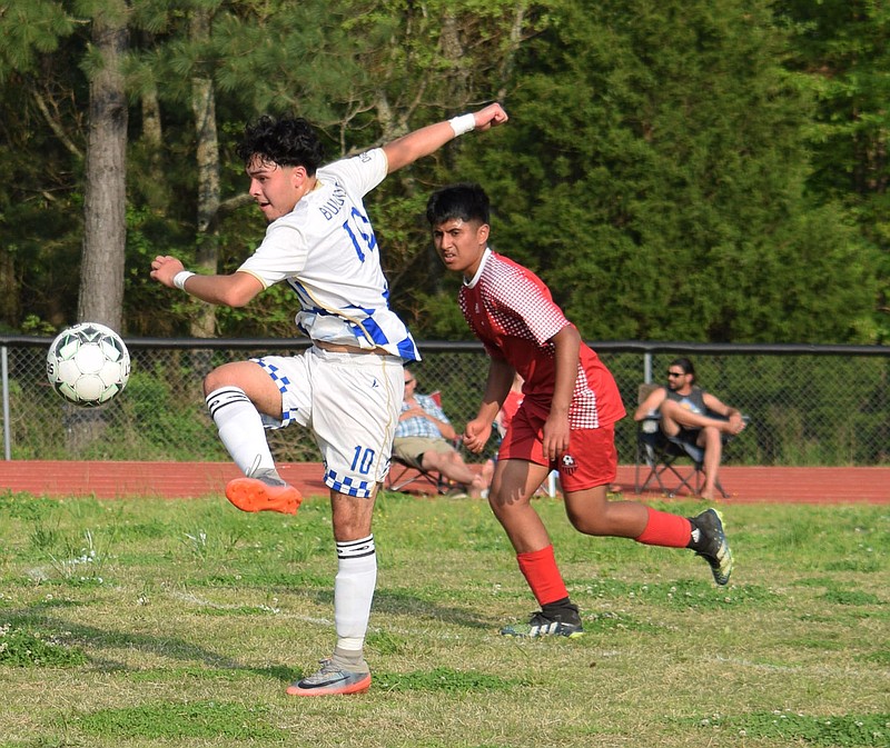 Westside Eagle Observer/MIKE ECKELS
Kenneth Barrios (10) uses a side-kick to clear the ball away from an approaching Highlander player during the May 9 Eureka Springs-Decatur soccer contest in Eureka Springs. The Bulldogs took the conference win 4-1 over the Highlanders.