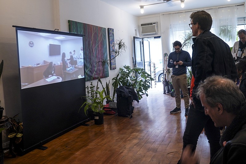 FILE - Amazon Labor Union (ALU) lead organizer Mat Cusick, second from right standing, watches a zoom-cast of vote counting to unionize Amazon warehouse on Staten Island, N.Y., Thursday, March 31, 2022, in New York.  Amazon has fired two employees with ties to the grassroots union that led the first successful U.S. organizing effort in the retail giant’s history. The company confirmed Tuesday, May 10,  it fired Michal, or ‘Mat,’ Cusick and Tristan Dutchin of the Amazon Labor Union in New York. It claims the cases are unrelated to each other and unrelated to any cause or group the two support. AP Photo/Bebeto Matthews, File)