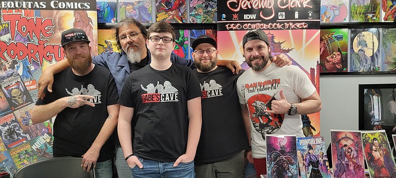 Uncle Nasty, professional comic book artist Tone Rodriguez, Gabe Rosson, Marty Rosson, and professional comic book inker Jeremy Clark pose on Free Comic Day in Gabe's Cave. (Michael Hanich/Camden News)