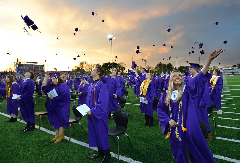 Lilli Carmen (right) joins other members of the 2021 senior class at Elkins High School in tossing her mortar board May 14, 2021, after receiving her diploma during commencement exercises at the school’s football field. The school graduated 95 seniors. 
(NWA Democrat-Gazette/Andy Shupe)