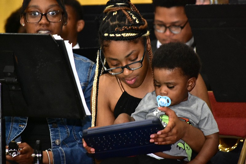 A band member holds a little guy and keeps him entertained during Watson Chapel High School's graduation ceremony Tuesday, May 10, 2022. (Pine Bluff Commercial/I.C. Murrell)