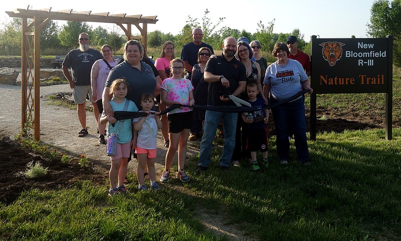 Attendees at the Partners in Education meeting Wednesday, May 11, 2022, celebrate the New Bloomfield R-3 School District's new walking trail and outdoor learning area with a ribbon cutting. (MICHAEL SHINE/FULTON SUN)