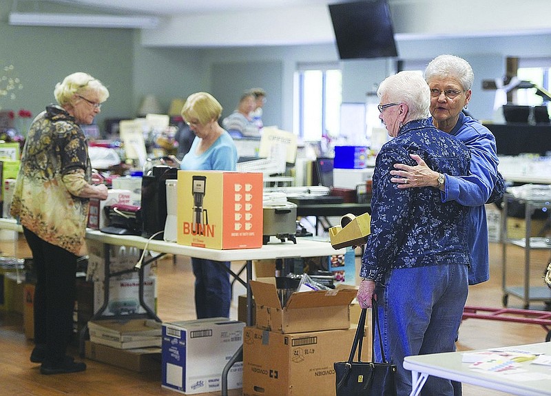 Suzanne Evans of Bella Vista (right) greets Glenda Redenius of Bella Vista during the setup of a previous "Flea."
(File photo)