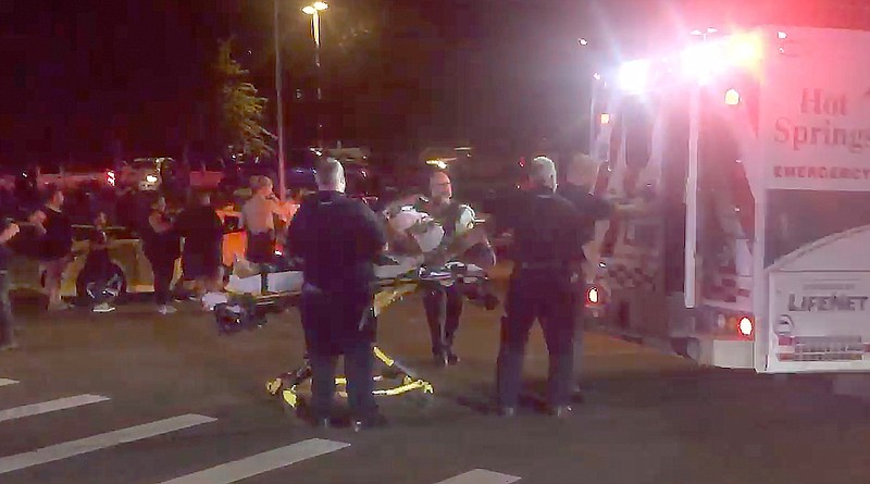 A shooting victim is loaded onto an ambulance Thursday at Convention and Laurel. - Photo by Steven Mross of The Sentinel-Record