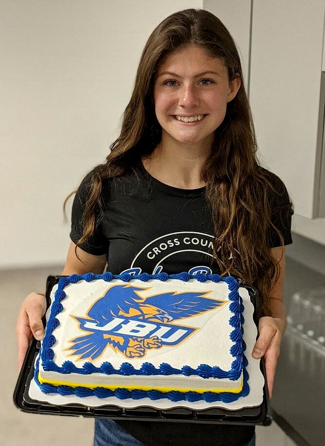 SUBMITTED
Gentry senior Maci Hubbard signed a letter of intent last month to attend John Brown University in the 2022-2023 school year and compete in its track program. She is pictured holding a cake in celebration of her signing.