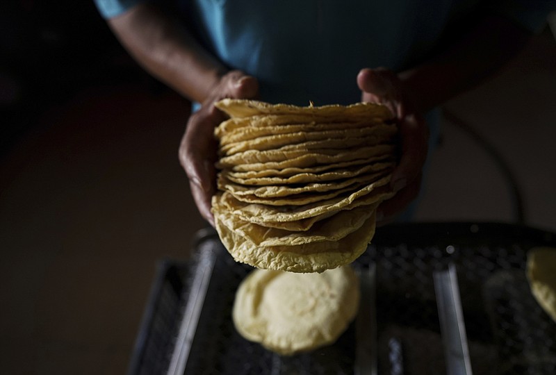 A worker packages tortillas to sell for 20 Mexican Pesos per kilogram, about one dollar, at a tortilla factory in Mexico City, Monday, May 9, 2022. Almost a year ago the same tortilla factory used to sell a kilo of tortillas for 10 Mexican Pesos. (AP Photo/Fernando Llano)