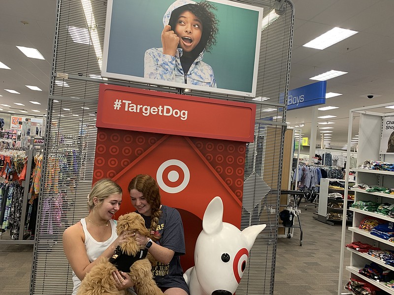 Ashlynn Gonzales and Savannah Smith share a laugh and cuddle with their dog, Charlie, in the clothing department Friday, May 13, 2022, at Target on Richmond Road in Texarkana, Texas. (Staff photo by Mallory Wyatt)