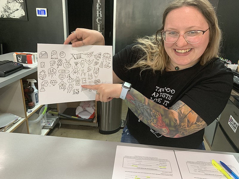 Mackenzie May shows off her favorite Friday the 13th tattoo design at Body of Art tattoo shop on Friday, May 13, 2022, in Texarkana, Texas. (Staff photo by Mallory Wyatt)