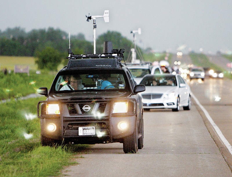 FILE - In this May 19, 2010 file photo taken near Kingfisher, Okla., storm chasers and spectator vehicles clog the road and shoulder of Highway 81. The subculture of chasing has gone mainstream in recent years, thanks to digital cameras and mobile radar. And it's getting more dangerous. Highways are increasingly clogged with chasers trying to beat each other in a risky race to capture the storms. Three storm chasers died Tuesday, March 28, 2017, in a collision as they raced toward a tornado-warned storm in West Texas, authorities said. (AP Photo/Sue Ogrocki, File)