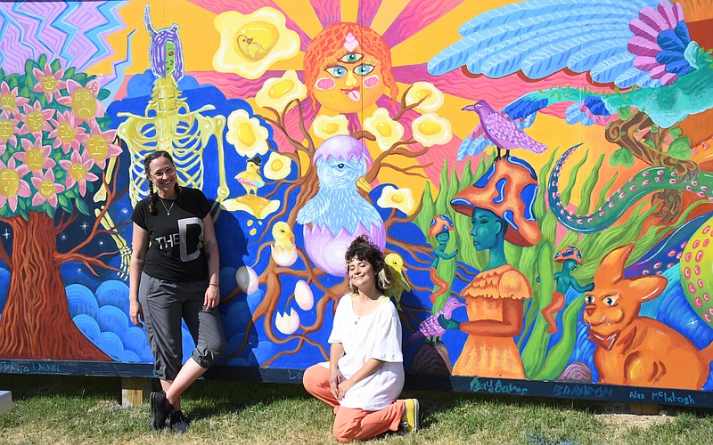 Erin Holliday, left, executive director of Emergent Arts, and artist Danaé Brissonnet are shown in front of the new mural Brissonnet helped a group of local teens paint at David F. Watkins Memorial Park. - Photo by Tanner Newton of The Sentinel-Record