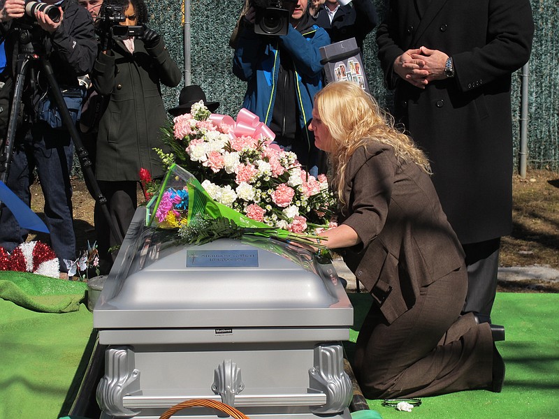 FILE &#x2014; Mari Gilbert prays over the coffin of her daughter, Shannan Gilbert, at Amityville Cemetery in Amityville, N.Y., March 12, 2015. Gilbert, whose disappearance in a Long Island beach community more than a decade ago sparked an investigation into a possible serial killer said &#x201c;there's somebody after me&quot; in a newly released 911 tape. But Suffolk County police said Friday, May 13, 2022, that they still believe that Gilbert's death near Gilgo Beach was a &quot;tragic accident&quot; and unconnected to the slayings of multiple other women whose remains were found in the same area in 2010 and 2011. (AP Photo/Frank Eltman, File)