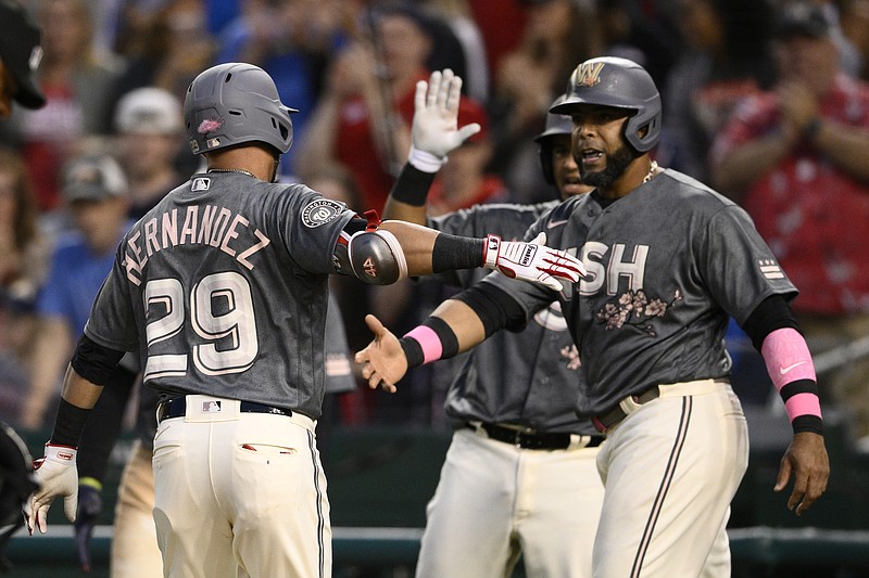 Washington Nationals' Yadiel Hernandez (29) celebrates his three-run home run with Nelson Cruz, right, during the third inning of a baseball game against the Houston Astros, Saturday, May 14, 2022, in Washington. (AP Photo/Nick Wass)