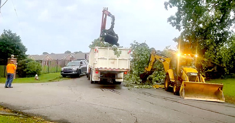 Hot Springs Street Division workers remove a fallen tree at the corner of Lakeland Drive and Chambers Point Sunday. The damage was caused by severe thunderstorms that moved through the area. - Photo by Beth Reed of The Sentinel-Record