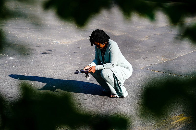 A person pauses outside the scene of a shooting at a supermarket, in Buffalo, N.Y., Sunday, May 15, 2022. (AP Photo/Matt Rourke)