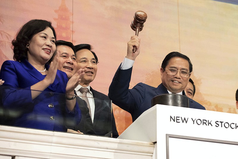 In this photo provided by the New York Stock Exchange, Vietnam's Prime Minister Pham Minh Chinh, right, gavels trading closed during closing bell ceremonies at the New York Stock Exchange, Monday, May 16, 2022. (Courtney Crow/New York Stock Exchange via AP)