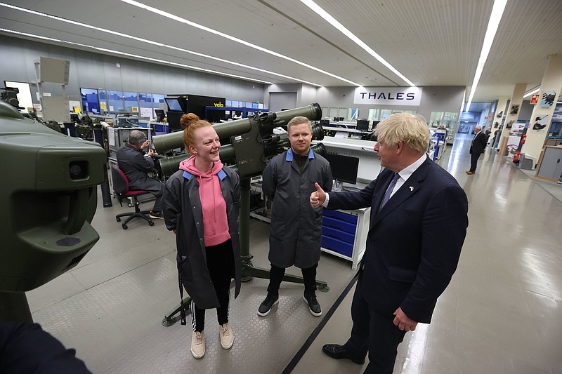 Britain's Prime Minister Boris Johnson meets Mechanical Apprentice Natalie Keenen, left, and Manufacturing Apprentice Nathan Warnock at Thales weapons manufacturer in Belfast, Monday May 16, 2022, during a visit to Northern Ireland. Johnson said there would be ?a necessity to act? if the EU doesn't agree to overhaul post-Brexit trade rules that he says are destabilizing Northern Ireland's delicate political balance. Johnson held private talks with the leaders of Northern Ireland's main political parties, urging them to get back to work. (Liam McBurney/Pool via AP)