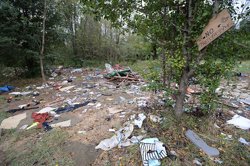 Remnants of a former camp cover the ground Oct. 15, 2021, at the former Safe Camp south of the 7 Hills Walker Residential Community in Fayetteville. The city spent $34,000 cleaning up debris from the camp, which was in operation from August 2020 to October 2021 to provide refuge for unsheltered residents during the covid-19 pandemic.
(File photo/NWA Democrat-Gazette/Andy Shupe)