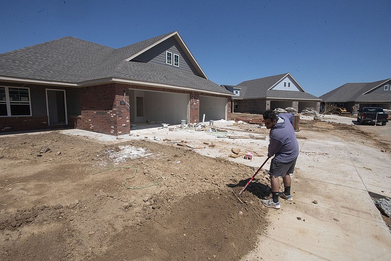 Hector Sandoval of Rogers works Monday May 16, 2022 at smoothing the yard at a newly constructed house in Farmington.  Visit nwaonline.com/220517Daily/ for daily galleries.  (NWA Democrat-Gazette/J.T. Wampler)