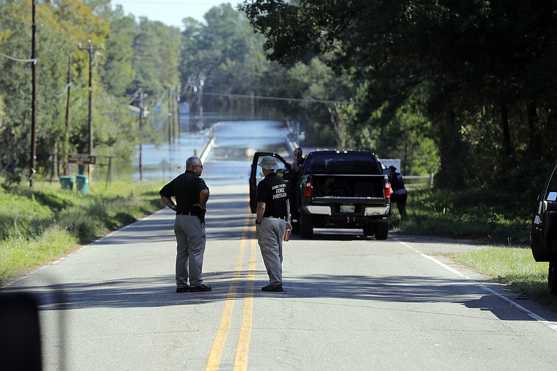 FILE - Responders congregate near where two people drowned the evening before when they were locked in a Horry County Sheriff's department transport van  in Marion County, S.C. A deputy charged in the deaths ignored barricades and drove into rapidly rising floodwaters against advice from his supervisors and officials on the South Carolina highway, a prosecutor said Monday, May, 16, 2022. (AP Photo/Gerald Herbert, File)