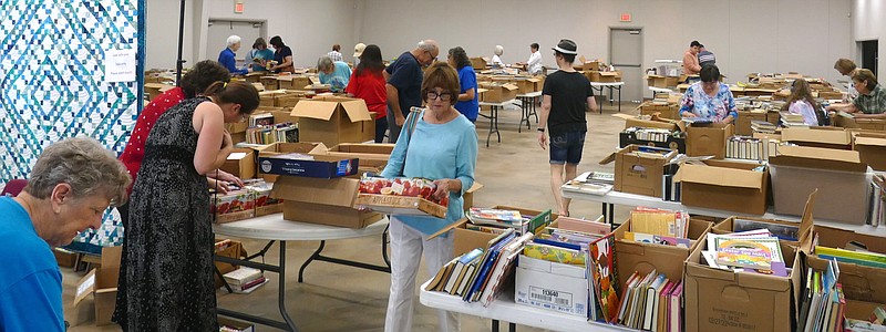Books still attract deep interest, especially during a library’s book sale, such as is going on here in Atlanta, Texas. Friends of the Atlanta Library have organized a book sale today through Saturday at the Mattie Lanier Richey Center, 101 Sportsplex Drive. (Photo by Neil Abeles)