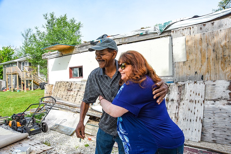 Susan Cook-Willliams receives a hug from Dwight Days Tuesday, May 17, 2022, after she told him that she found someone who would store his items free of charge. They are shown at his Jefferson City home at 500 E. Ashley St., a structure in where he has not been able to live since the May 22, 2019 tornado left it heavily damaged. Cook-Williams is the executive director of River City Habitat for Humanity, one of the organizations that will help with the re-build. Days is the 611th tornado victim that the Long Term Recovery Committee has aided and will will help pay for replacing his home. (Julie Smith/News Tribune photo)